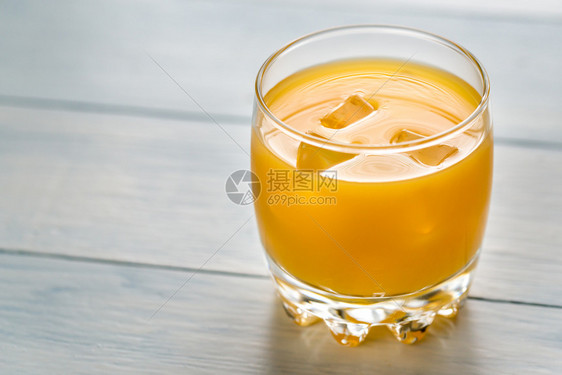 木制桌上的芒果汁杯子图片