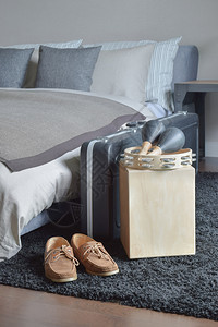 塔布林木箱上的马拉加和床旁黑地毯上的皮鞋图片