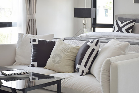 床边白色沙发上的黑和白图形打印枕头高清图片
