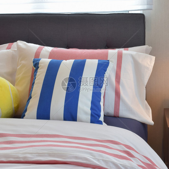 现代卧室内床上有彩色条纹枕头图片