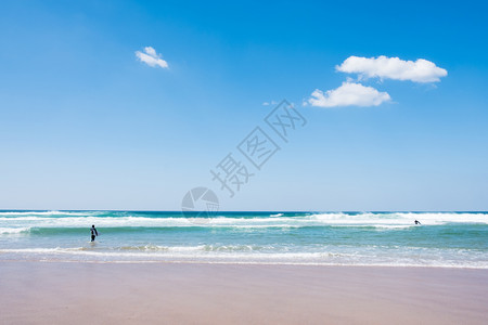 蓝洋水上有冲浪板的不明身份男子背面景象图片