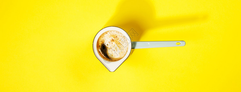 具有创意的平板铺黄色背景的蓝土黄锅中的咖啡文本空间黄色背景的咖啡平板最高视图图片
