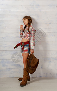 戴着宽的牛仔帽和穿着传统服装的小女孩摆姿势拍照图片