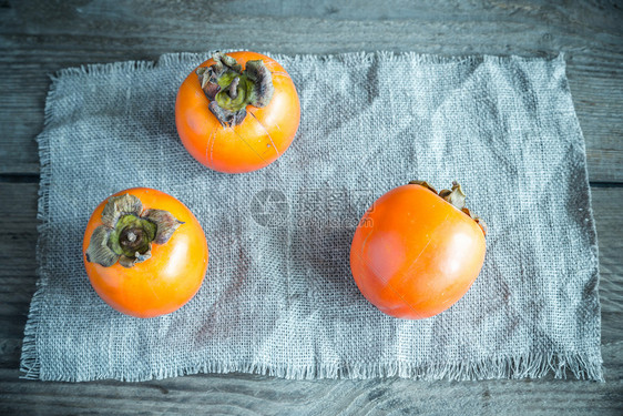 木背景上新鲜的persimmons图片