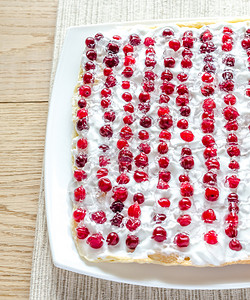 奶香蔓越莓蛋糕用奶油和新鲜的红莓奶油红莓背景