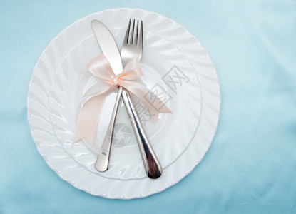 白色盘子叉和刀放在浅色背景上图片