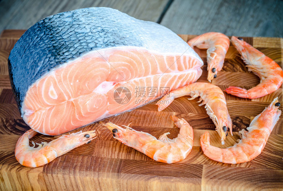 木板上的生鲑鱼和虾图片
