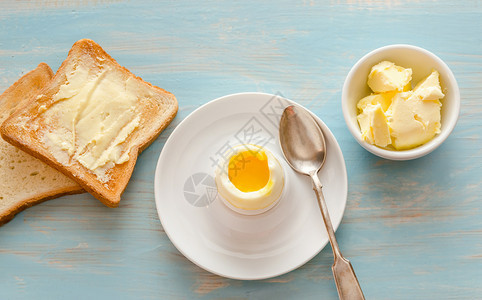 木制桌上烤鸡蛋和面包图片