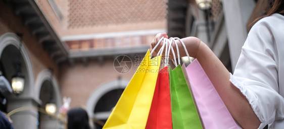 亚洲女孩持有销售袋的购物中心消费主义生活方式概念图片