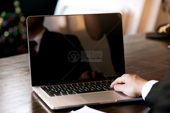 男人在木制桌上使用笔记本电脑工作手打字在键盘上图片