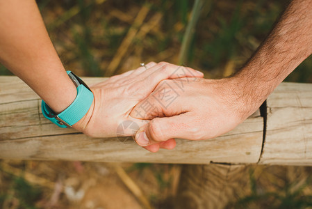 情侣在木栅栏上牵手特写图片素材