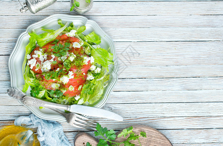 蔬菜沙拉加绿色番茄切片和金属盘上的食物图片