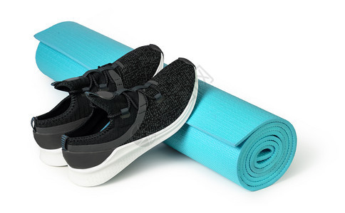 白背景孤立的运动鞋和瑜伽垫子图片