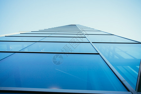 现代办公大楼玻璃窗外的蓝色摩天大楼图片