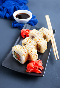 寿司有鲑鱼和姜汁在黑盘子上图片