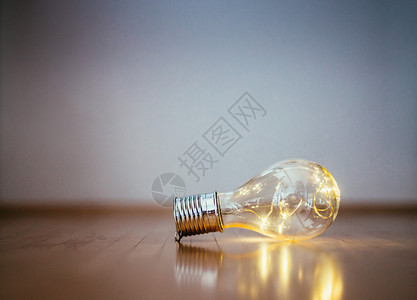 LED灯泡躺在木制地板上有创意和革新的标志复制空间图片
