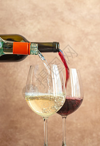 白葡萄酒和红倒入杯子紧贴图片
