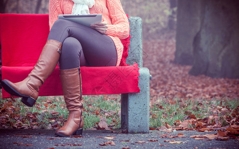 外边有秋天时间的人有数字板美女坐在长椅上穿秋装的年轻女士有数字板的美女图片