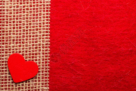情人节或婚礼概念木质装饰心脏在抽象的红布背景上撕裂丝带边界框架图片
