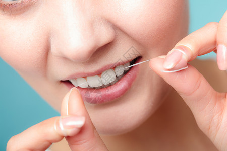 口腔卫生和保健微笑的妇女使用牙科线白健康齿用线微笑的妇女图片