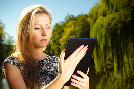 女在公园休息和使用平板电脑子书在户外闲暇时间图片