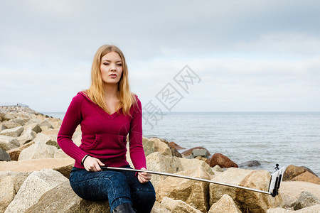 美丽的海边景色概念岩石阴云天的海平面女人看着美丽的风景图片