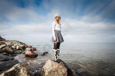 女人站在海边岩石上看风景图片