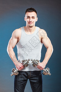 健壮体强的人与哑铃一起锻炼肌肉健壮的年轻人举重深蓝背景图片