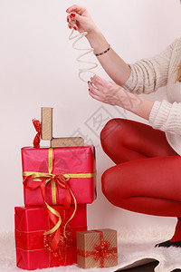 穿着高跟鞋的女子红丝袜许多礼物将手镯放在盒中圣诞节庆祝概念图片