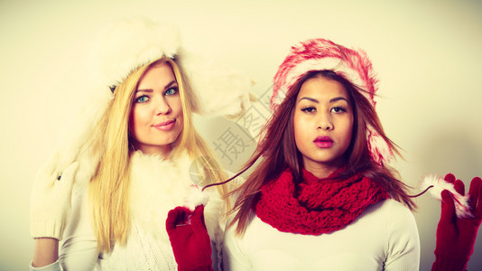 时装冬人概念两个穿冬装的女孩着毛帽的迷人女图片
