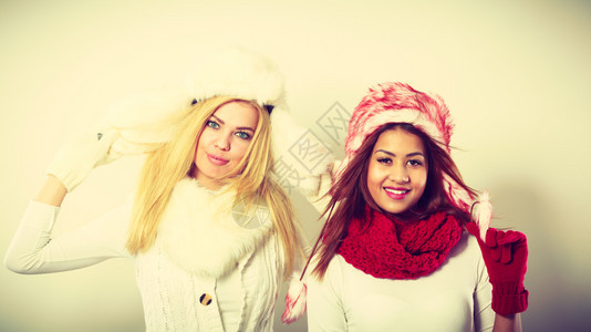 时装冬人概念两个穿冬装的女孩着毛帽的迷人女图片