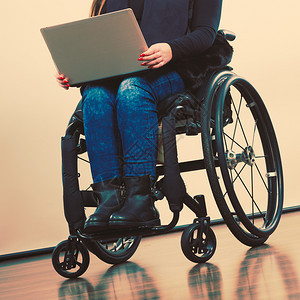 技术和移动设备使用膝上型计算机的残疾女孩轮椅上的年轻女商业工人使用轮椅上的膝型计算机残疾妇女图片