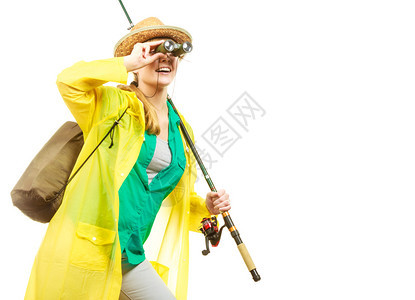 穿雨衣的妇女拿着鱼棒和望远镜准备冒险图片