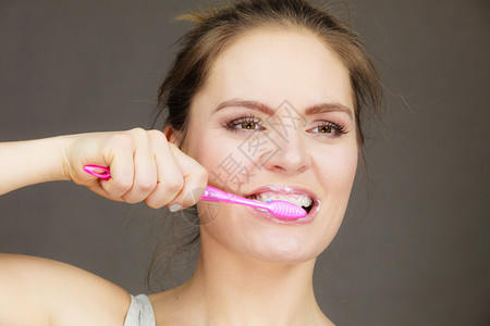 妇女刷牙口腔卫生黑暗背景背景图片