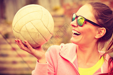 参加运动用太阳镜的女青年排球运动员在户外举行球赛图片