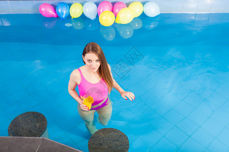 漂亮女孩在游泳池放松享受水图片