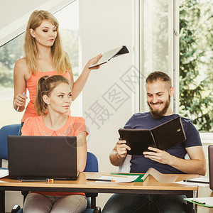 教学辅助技术概念女青年教师或在课堂上与成人学生一起上课有文件膝上型计算机笔记本电脑学习课程堂生和教师辅导图片