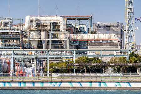 日本东京附近川崎市烟雾中含有天然气储存和管道结构的化工厂背景图片