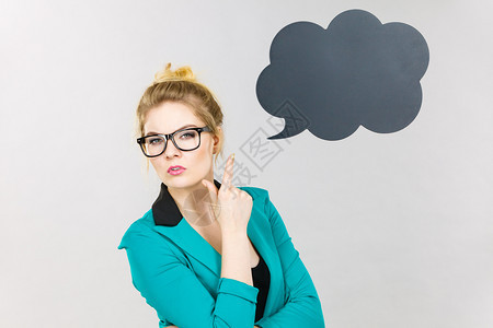 身穿蓝色夹克和眼镜的商业妇女强烈的思考寻找大问题解决方案黑色思维或言语泡沫紧挨着她图片