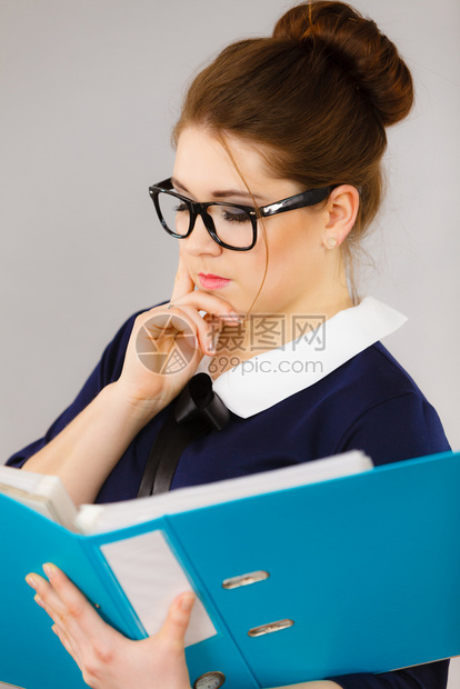 手持蓝文件夹的女办公室工作人员代理年轻优雅的女商人或秘书有文件账单思考面部表情在灰色上的商业和文书工作有件的档案夹图片