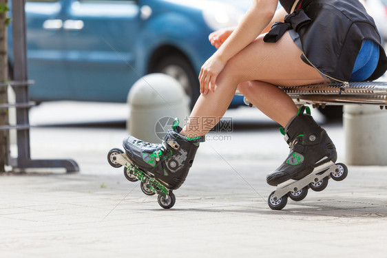妇女穿着溜冰鞋在城里坐着夏季妇女运动很活跃图片