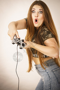 青年成女子在视频控制台玩游戏平,概念。图片