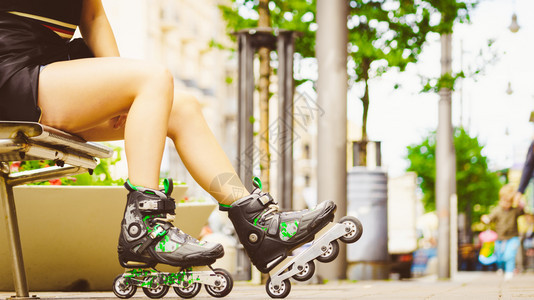 妇女穿着溜冰鞋在城里坐着夏季妇女运动很活跃图片