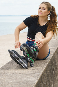 有吸引力的年轻女子穿着溜冰鞋乘飞机后放松女在夏季海边玩得开心女孩在海边穿着溜冰鞋图片