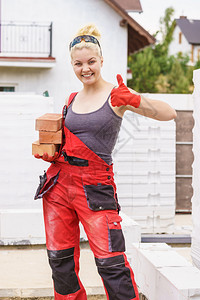 在建筑工地房安装砖头工业程概念用砖头建造强力妇女筑图片