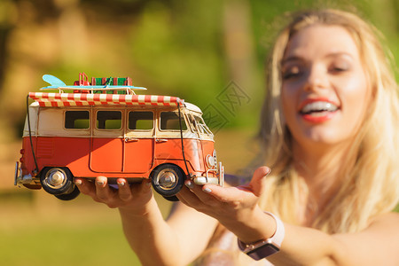 拥有旅行想法的快乐妇女持有嬉皮士露营拖车装饰物体模型车辆暑假概念图片