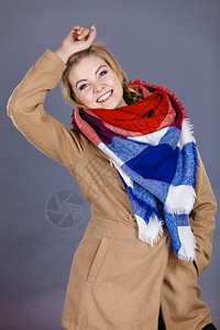 穿着浅棕色大衣和彩围巾的妇女冬季时装概念穿着彩色围巾的妇女穿着浅褐色大衣和彩围巾的妇女图片