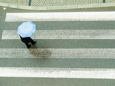 雨天时在城市街上行走的人拿着雨伞背景图片