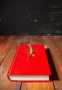 圣洁的经上面有红色的封在旧黑暗木质表面铁链上有一个小金属图片