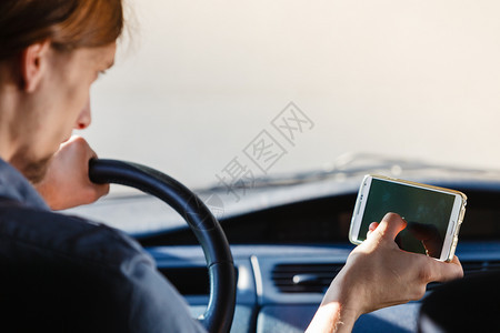 现代技术概念人驾驶汽车时使用移动电话检查社交媒体或设置导航人驾驶汽车时使用手机图片
